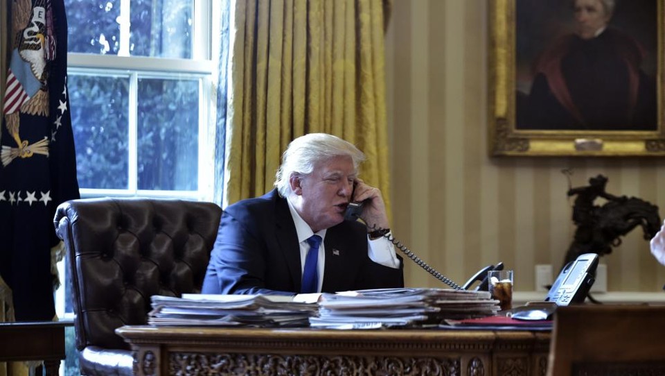 Trump em conversa por telefone com o presidente russo, Vladimir Putin, no Salão Oval, neste sábado (28). | Mandel Ngan/AFP