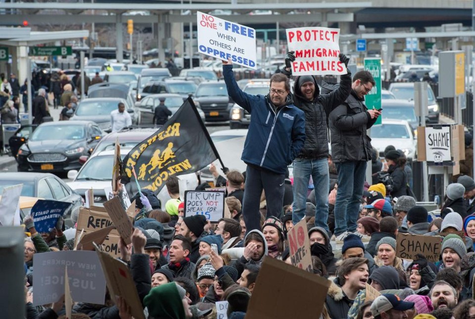 Manifestantes estão na porta do Aeroporto Internacional JFK, em Nova York, protestando contra as medidas de Trump. | BRYAN R. SMITH/AFP