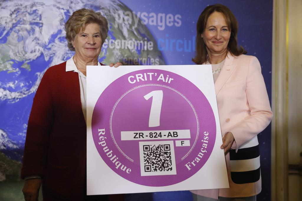 A ministra francesa de Ecologia, Desenvolvimento Sustentável e Energia, Segolene Royal (direita), apresenta um dos selos anti-poluição que serão exigidos dos carros para circular em Paris. | PATRICK KOVARIK/AFP