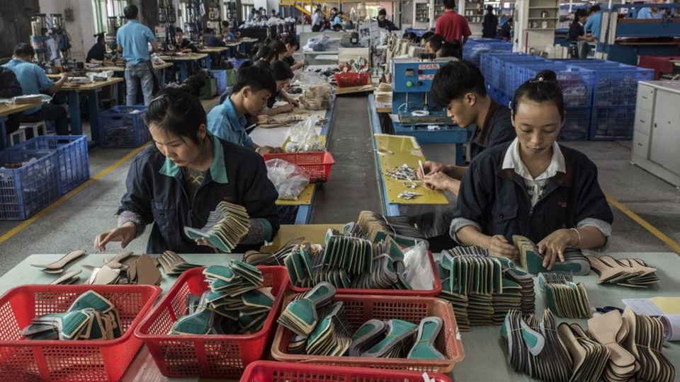 Trabalhadores, na China, fazendo solas de sapato para a marca de Ivanka Trump | GILLES SABRIE/NYT