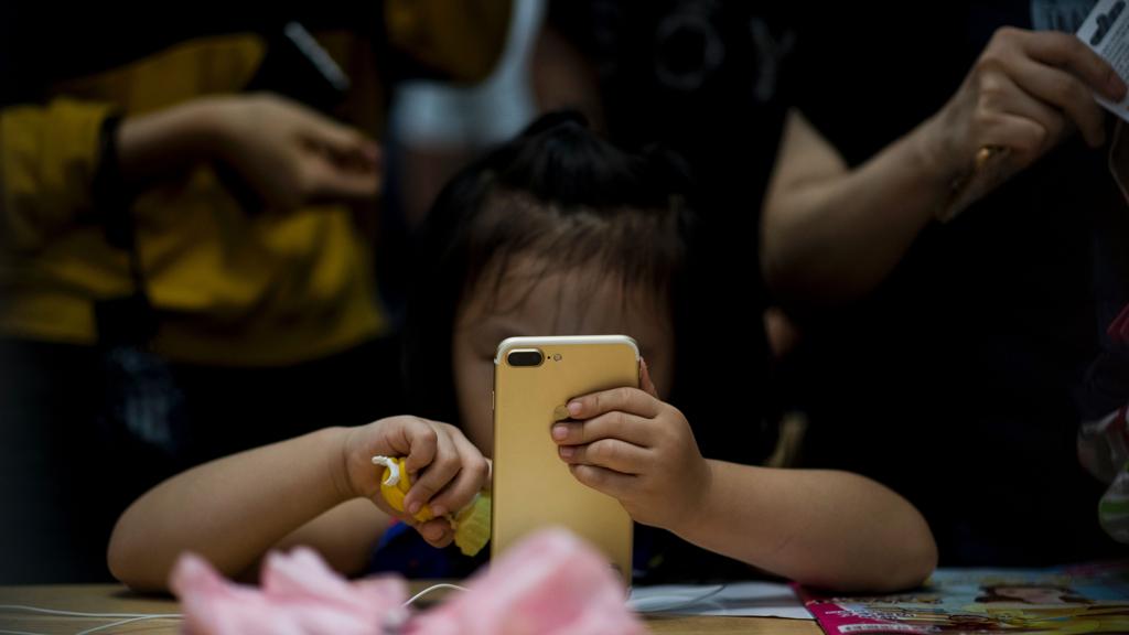 Criança chinesa brinca com um iPhone 7: mercado chinês é cobiçado pelas gigantes da tecnologia. | JOHANNES EISELE/AFP