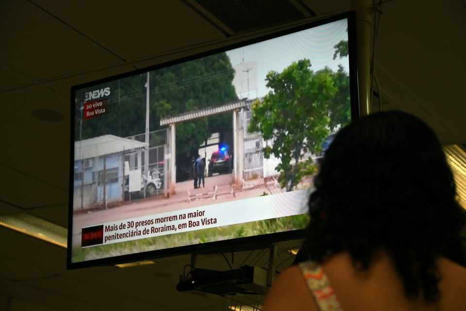 Mulher acompanha cobertura jornalística sobre o massacre em Roraima | Vanderlei Almeida/AFP