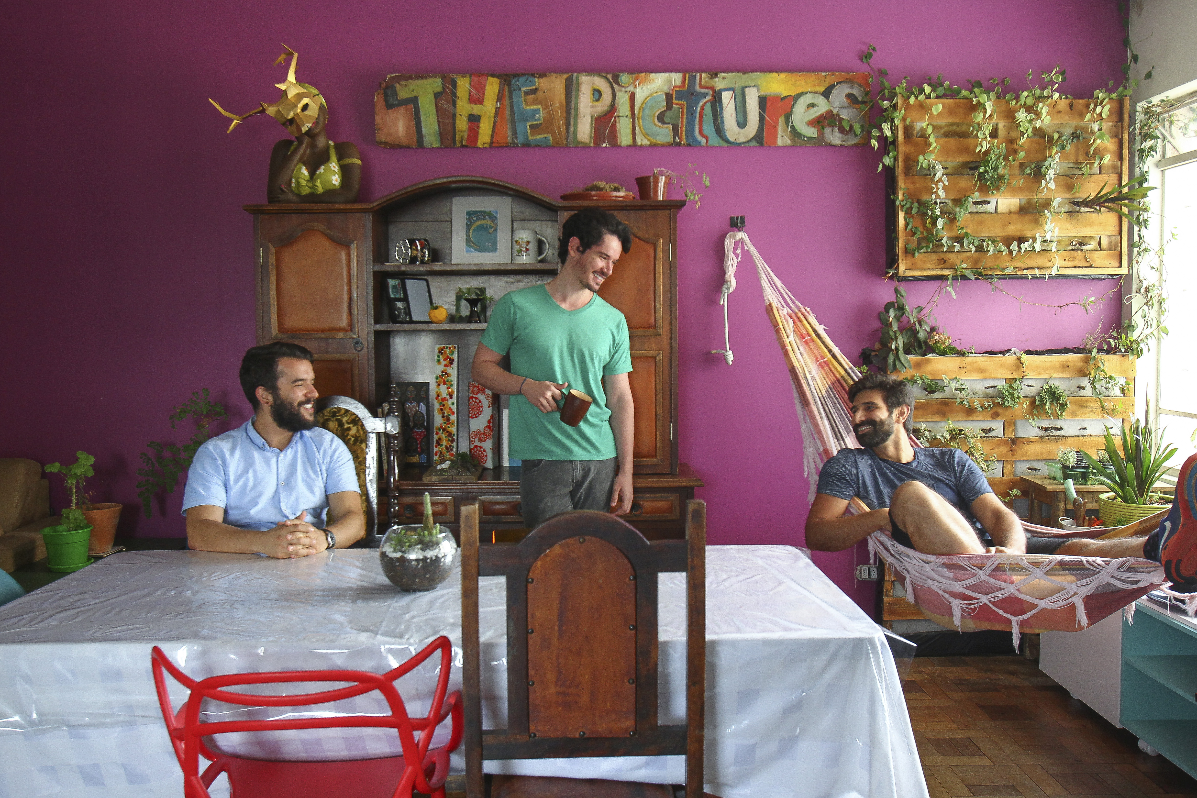 Co-living: morar com estranhos é opção na cidade do futuro. Frederico Medeiros (na rede) divide a casa em Curitiba com Guilherme Spiller (verde) e André Gava (azul claro). Ele adotou esse modo de viver  na Europa, há nove anos, e não largou mais. | Daniel Castellano/Gazeta do Povo