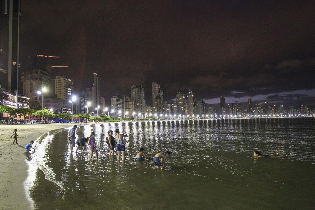Família na praia, à noite, em Balneário Camboriú | Daniel Castellano/GAZETA