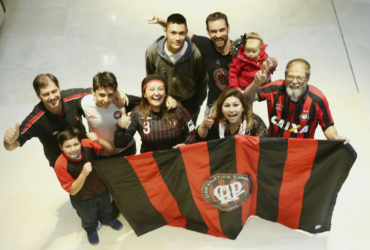 Fernando Torino (com a filha Helena no colo) e Alexandre Selski, abraçado com os filhos, fazem a festa com atleticanos na Colômbia. | Hugo Harada, enviado especial/Gazeta do Povo