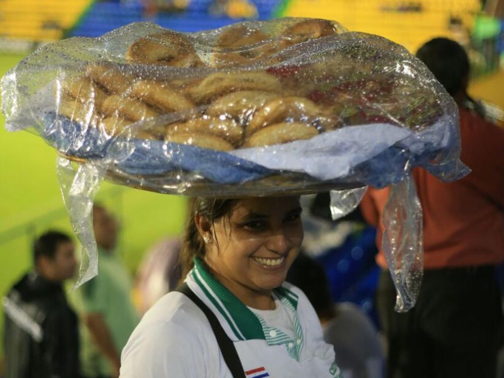 Vendedora de chipas caminha nas arquibancadas durante o confronto entre Capiatá e Atlético. | Daniel Castellano/Gazeta do Povo