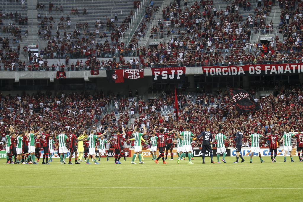 Cena mais marcante do Atletiba que não aconteceu, com os jogadores das duas equipes de mãos dadas no centro de campo. | Jonathan Campos/Gazeta do Povo