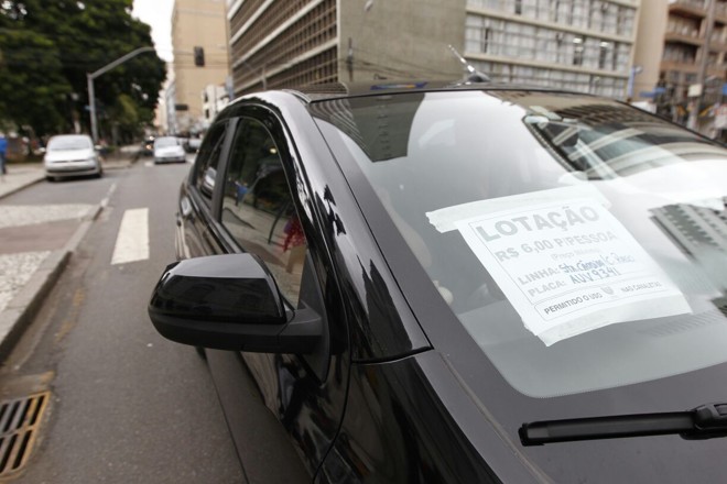 Carro passa pela praça Santos Andrade com autorização da URBS para transportar passageiros e circular pelas canaletas de ônibus. | Jonathan Campos/Gazeta do Povo