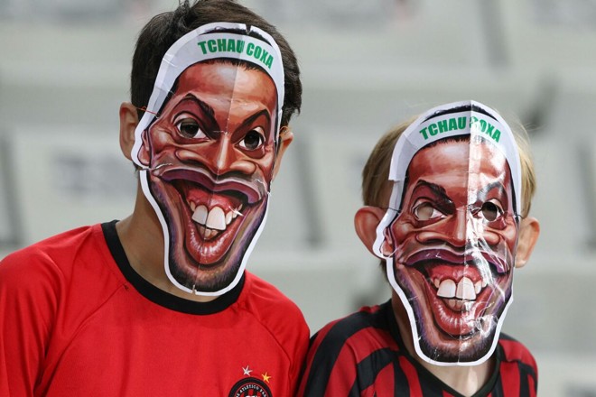 Provocação na arquibancada. Atleticanos aproveitam o duelo com o Coritiba para zoar o rival pela novela que terminou na não contratação do meia Ronaldinho Gaúcho. Máscaras do dentuço com um “Tchau Coxa” estavam entre os trajes vistos no estádio. | Daniel Castellano/Gazeta do Povo
