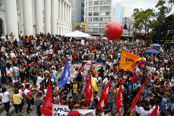 Faixas, bandeiras e até mesmo uma bola inflável é vista na concentração dos manifestantes na praça Santos Andrade. | Henry Milleo/Gazeta do Povo