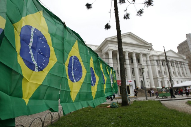 Bandeiras do Brasil são estendidas em frente ao prédio da UFPR na praça Santos Andrade, local de concentração de protesto contra a reforma da previdência. | Jonathan Campos/Gazeta do Povo