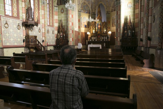 Fiel faz prece na igreja durante a tarde de terça-feira (21). | Marcelo Andrade/Gazeta do Povo