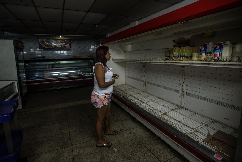 Venezuelana observa as prateleiras de um supermercado no  país vizinho. Cada vez mais, tudo falta na Venezuela. | MERIDITH KOHUT/NYT