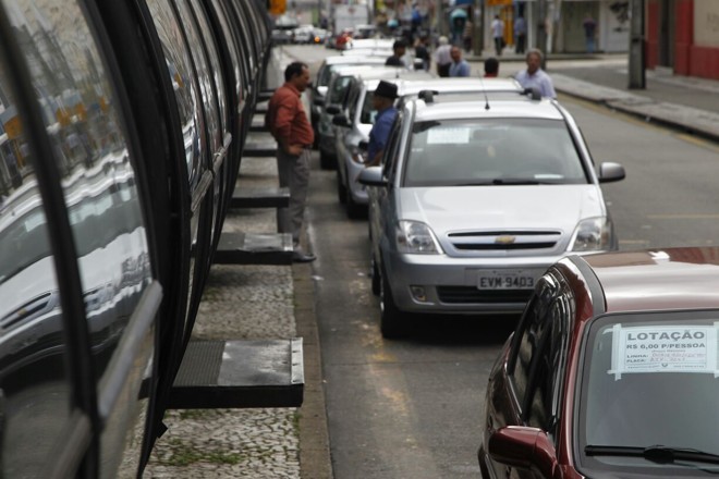 Carros de lotação, ou seja, carros particulares cadastrados pela Urbs para transporte nesta quarta-feira (15), aguardam na praça Carlos Gomes. | Jonathan Campos/Gazeta do Povo