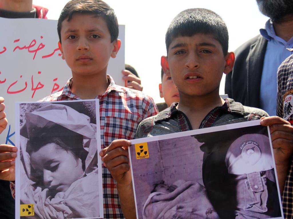 Moradores de Khan Sheikhun, pequena cidade da província rebelde de Idlib, mostram imagens de crianças atingidas pelo ataque com armas químicas promovido pelo governo sírio. | Omar Haj Kadour/AFP