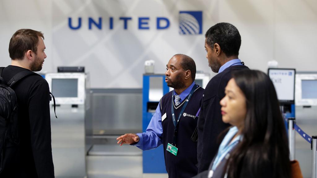 Funcionário da United Airlines conversa com passageiro: empresa perdeu grande valor em ações depois do incidente | Joshua Lott/AFP