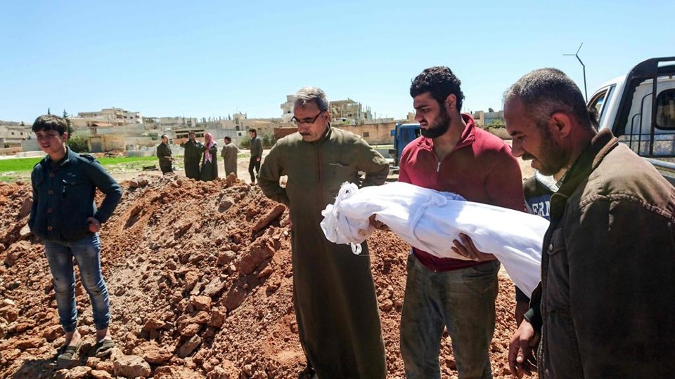 Moradores enterram o corpo de uma vítima do ataque com gás químico em Sheikh Khanoun, cidade na província de Idlib, no norte da Síria. | Fadi Al-Halabi/AFP