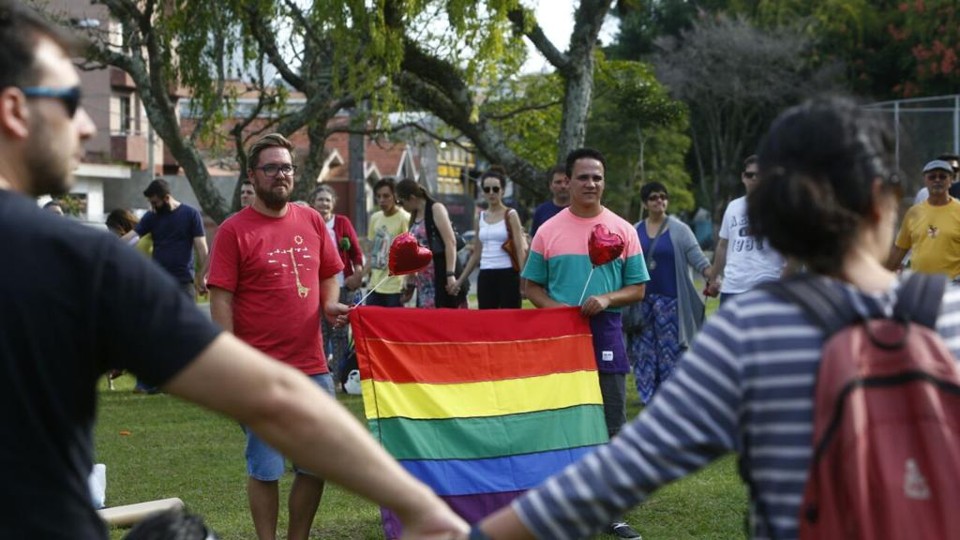 Ato reúne amigos e vizinhos contra panfleto homofóbico no Água Verde João Pedro e Bruno (com a bandeira) recebem apoio de amigos e vizinhos após serem vítimas de panfletos apócrifos | Henry Milléo/Gazeta do Povo