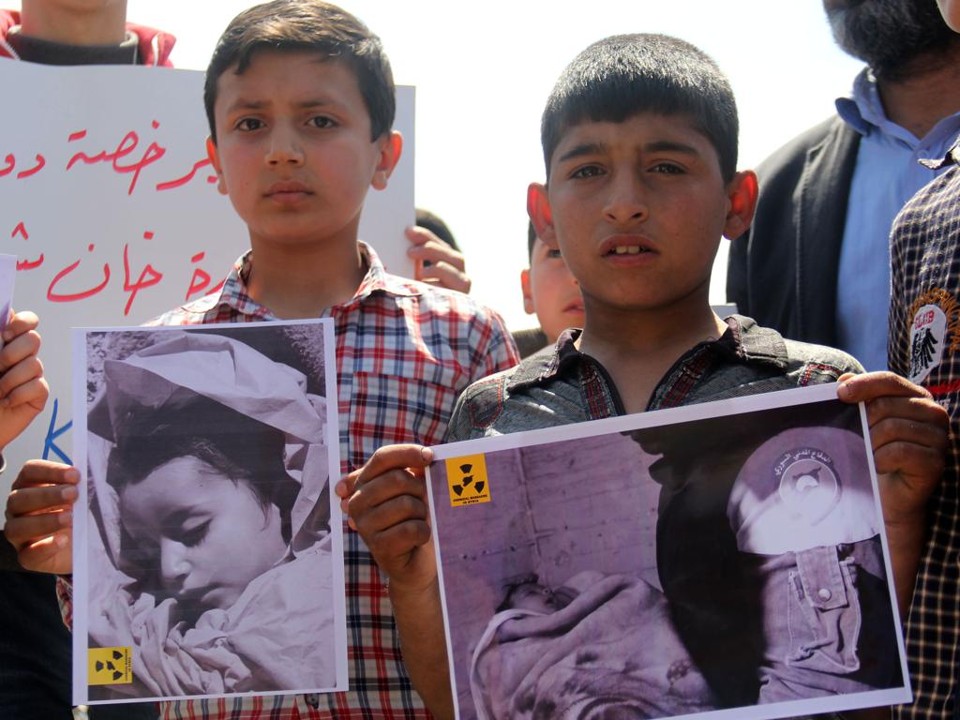 Garotos seguram fotos com vítimas do ataque químico a Khan Sheikhoun: Assad não é estúpido, apenas usou a mesma estratégia que sempre deu certo | Omar Haj Kadour/AFP
