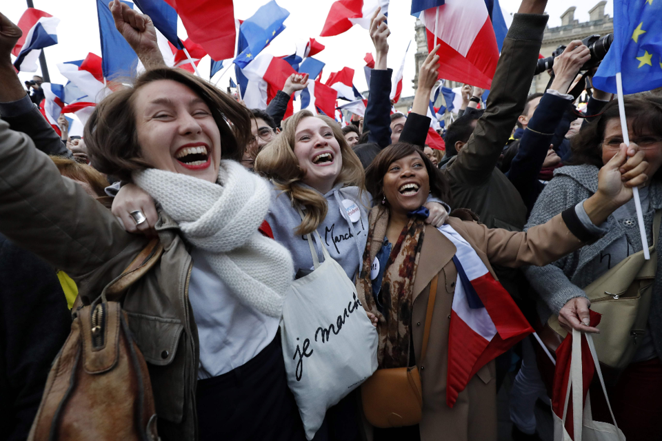 Eleitores do candidato Emmanuel Macron celebram a vitória sobre Marine Le Pen em frente à pirâmide do Louvre, em Paris, neste domingo (07). O candidato obteve 90% dos voto na capital francesa | PATRICK KOVARIKAFP