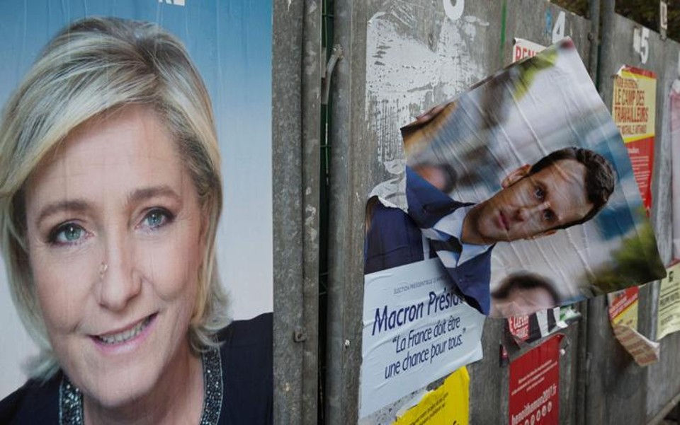 Foto feita no dia 24 de abril, um dia após o primeiro turno das eleições francesas, em Henin-Beaumont mostra cartazes das campanhas de Marine Le Pen, da Frente Nacional, e do candidato Emmanuel Macron, do movimento En Marche!: até Macron se rendeu às pautas de Le Pen | JOEL SAGET
AFP