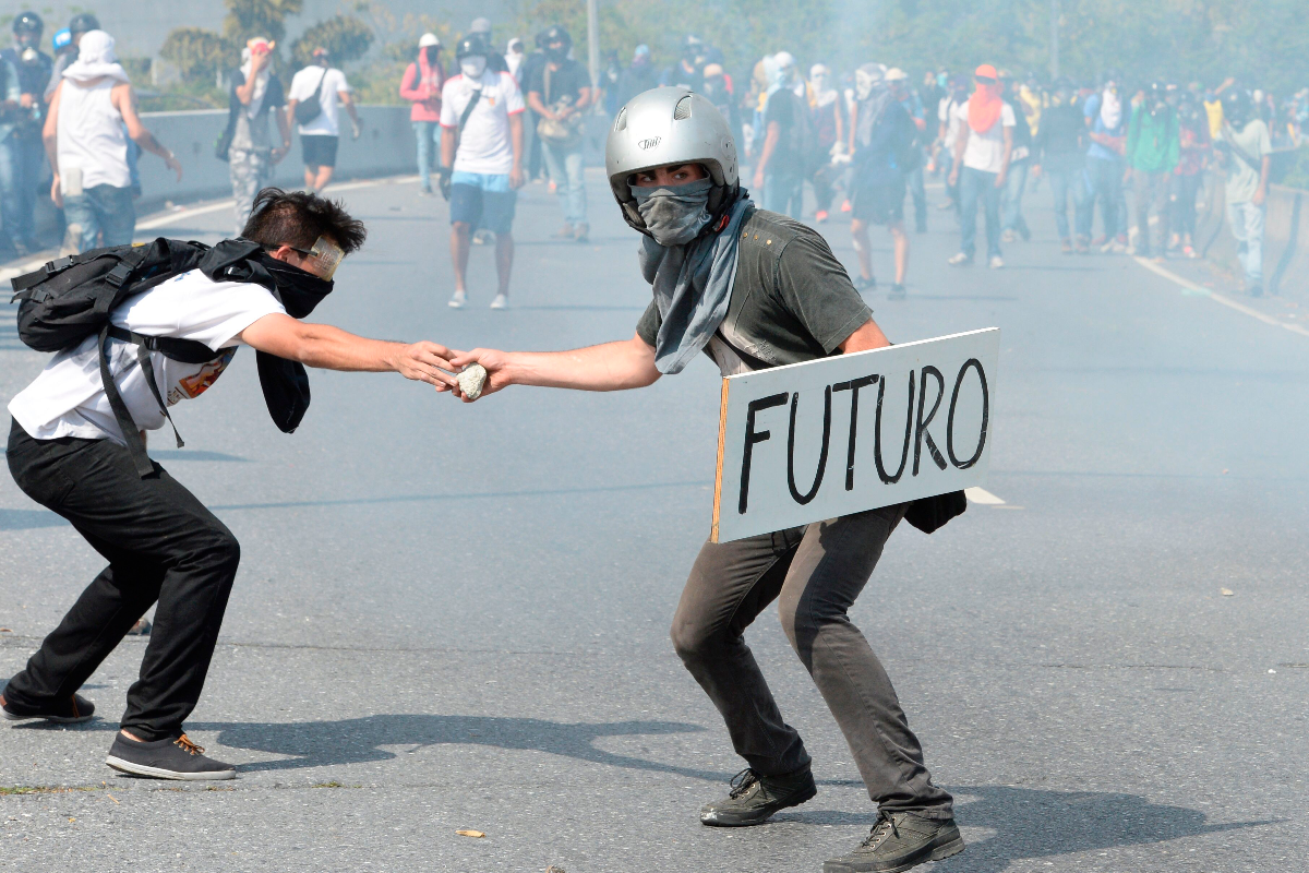 Manifestante participa de protesto contra o regime Maduro. Ditador venezuelano usou referendos para solapar a democracia no país sul-americano | FEDERICO PARRAAFP