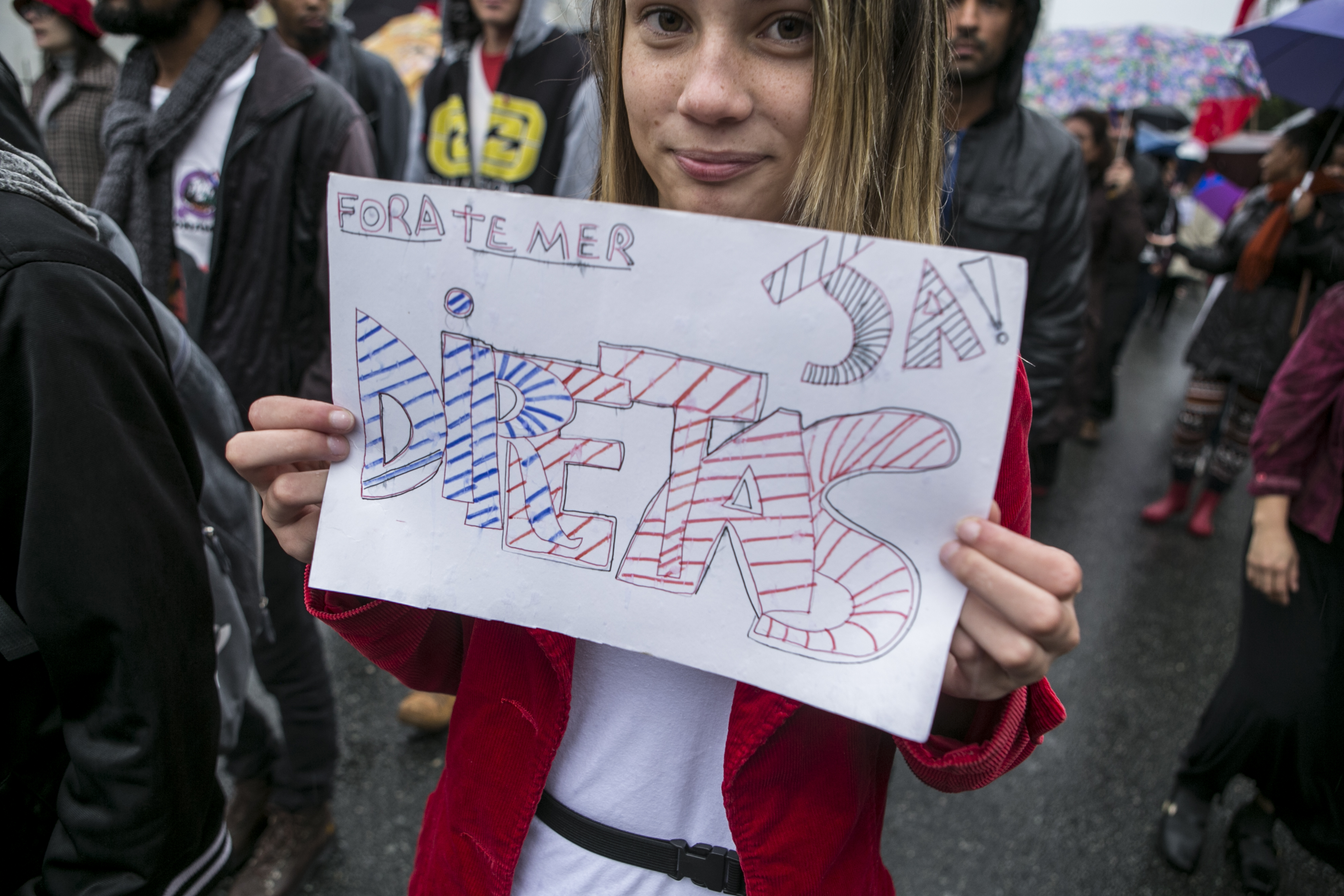 Jovem segura cartaz durante manifestação contra o presidente Michel Temer realizada no domingo (21), em Curitiba | Marcelo Andrade/Gazeta do Povo