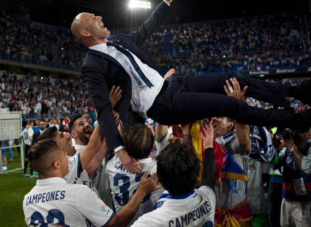 Jogadores do Real Madrid jogam o técnico Zidane para o alto na comemoração do título espanhol. | Sérgio Camacho/AFP