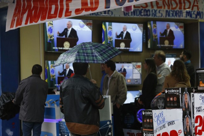 População assiste ao pronunciamento de Temer em loja na rua Marechal Deodoro, no Centro de Curitiba | Átila Alberti/Tribuna do Paraná /