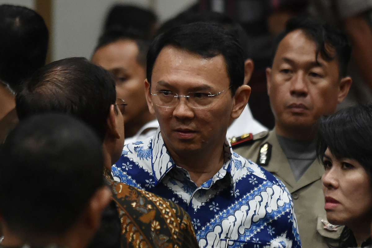 O governador cristão Basuki Tjahaja Purnama (C), conhecido popularmente conhecido como Ahok, fala com seu advogado depois do juiz sentenciá-lo a dois anos de prisão por blasfêmia | BAY ISMOYOAFP