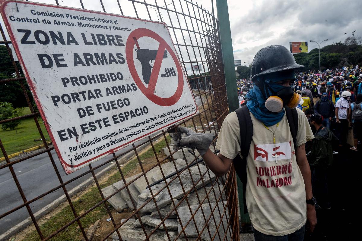 Manifestantes em frente à base da Força Aérea venezuelana | FEDERICO PARRAAFP