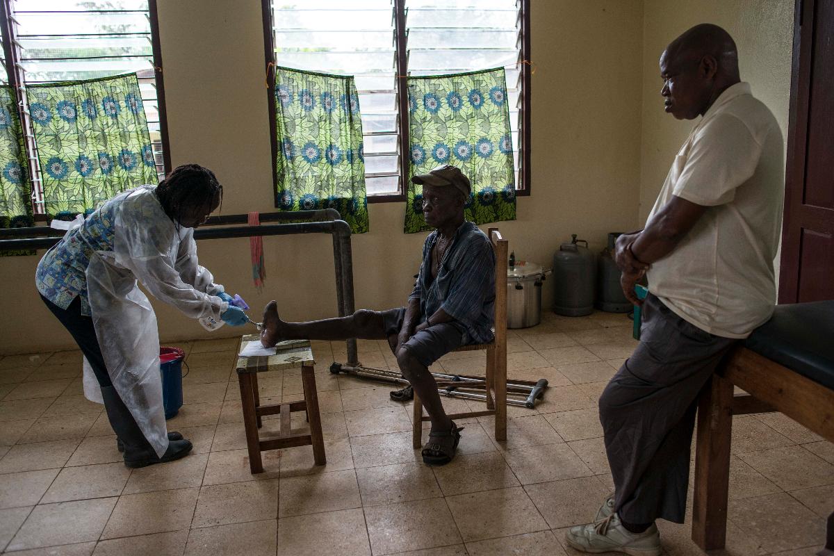 Bindu Daddah, à esquerda, cuida das feridas de John Flomo, causadas pela lepra, no leprosário de Ganta, na Libéria: em todo o mundo, o número de casos de lepra caiu 97% desde 1985 | MONIQUE JAQUES/NYT