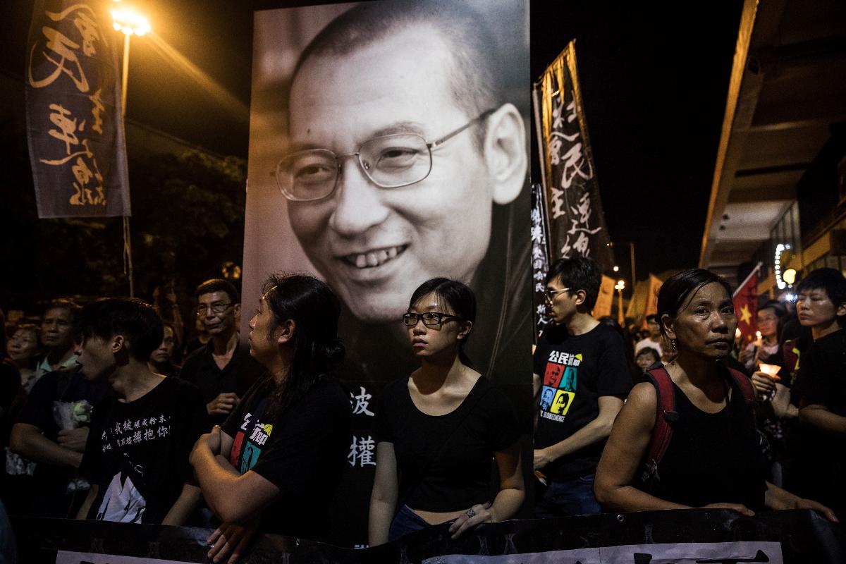 Apoiadores marcham em Hong Kong na memória de Liu Xiaobo, Prêmio Nobal da Paz de 2010 | DALE DE LA REY / AFP