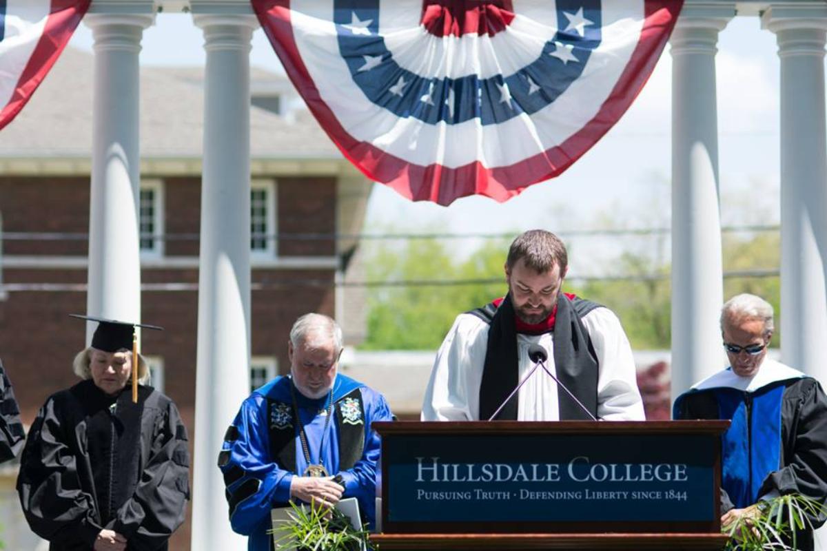 Capelão de Hillsdale, Rick Adam, conduz oração na formatura deste ano | Facebook / Hillsdale College