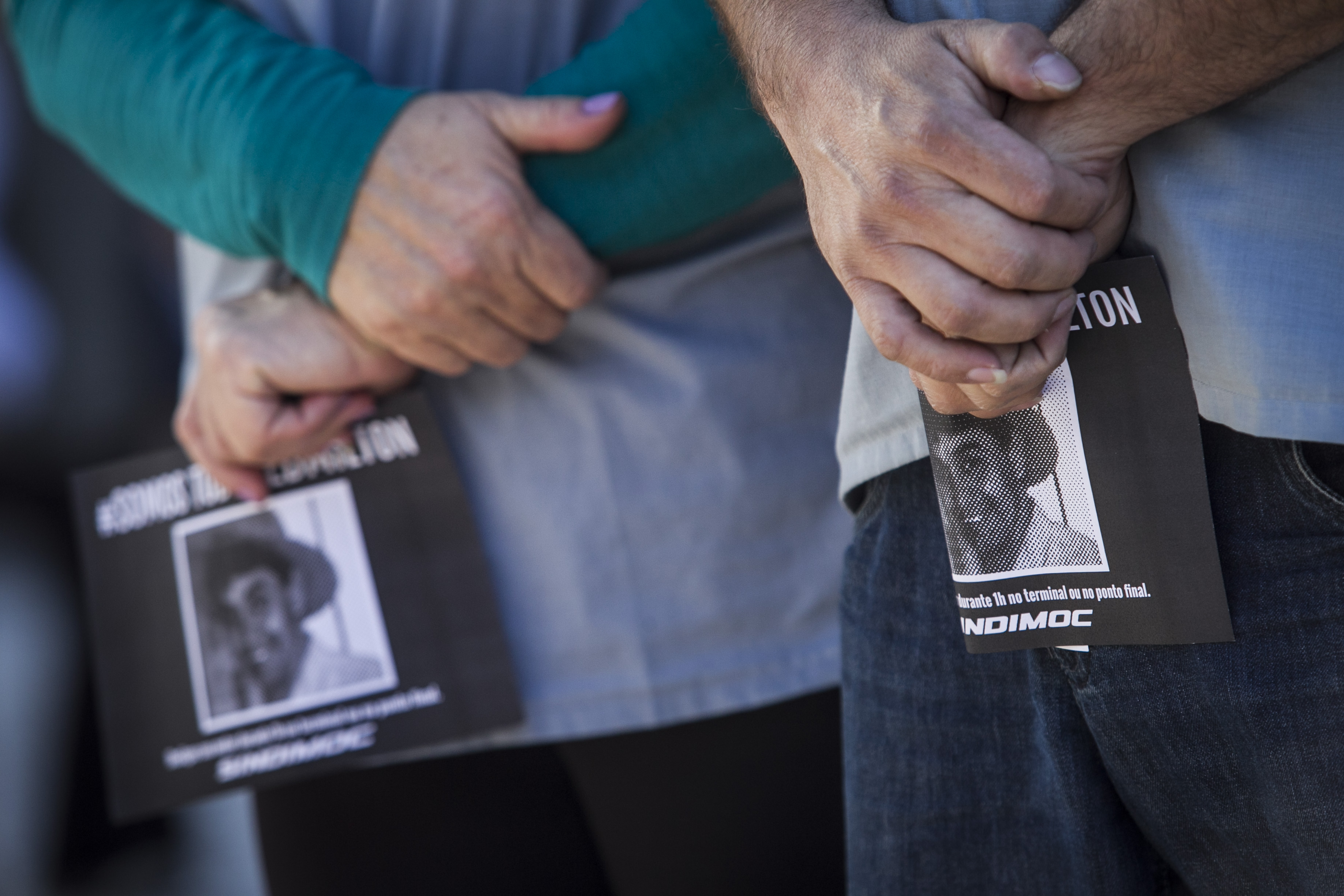 Trabalhadores seguram panfleto com a foto do motorista assassinado durante ato na Praça Rui Barbosa | Daniel Caron/Gazeta do Povo