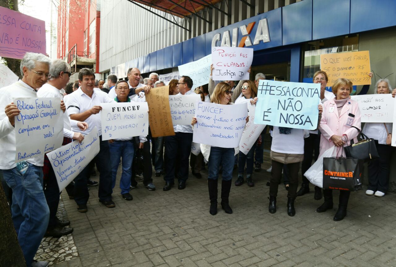 Protesto de servidores e aposentados não impede o atendimento na agência da Caixa na Praça Carlos Gomes. | Aniele Nascimento /Gazeta do Povo