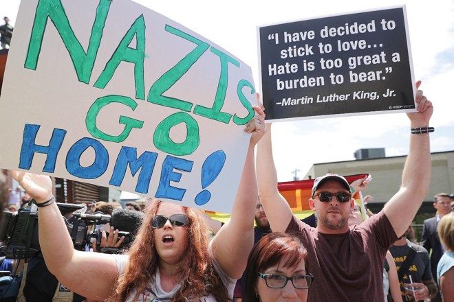 Manifestantes gritam insultos e fazem barulho na tentativa de abafar coletiva de imprensa realizada pelo blogueiro alt-right Jason Kessler, no dia 13 de agosto de 2017, em Charlottesville, Virgínia. Kessler, que ajudou a organizar a reunião do Unite the Right um dia antes, responsabilizou as autoridades de Charlottesville e a polícia por não terem protegido os direitos da primeira emenda dos participantes da manifestação: supremacistas brancos, neonazistas, membros Ku Klux Klan e alt-right | CHIP SOMODEVILLA/AFP