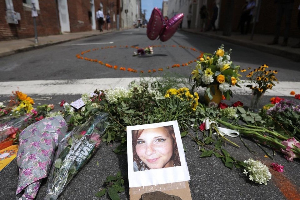 Flores ao redor da foto de Hather Heyer, 32 anos, morta durante protestos em Charlottesville, na Virginia | CHIP SOMODEVILLA/AFP