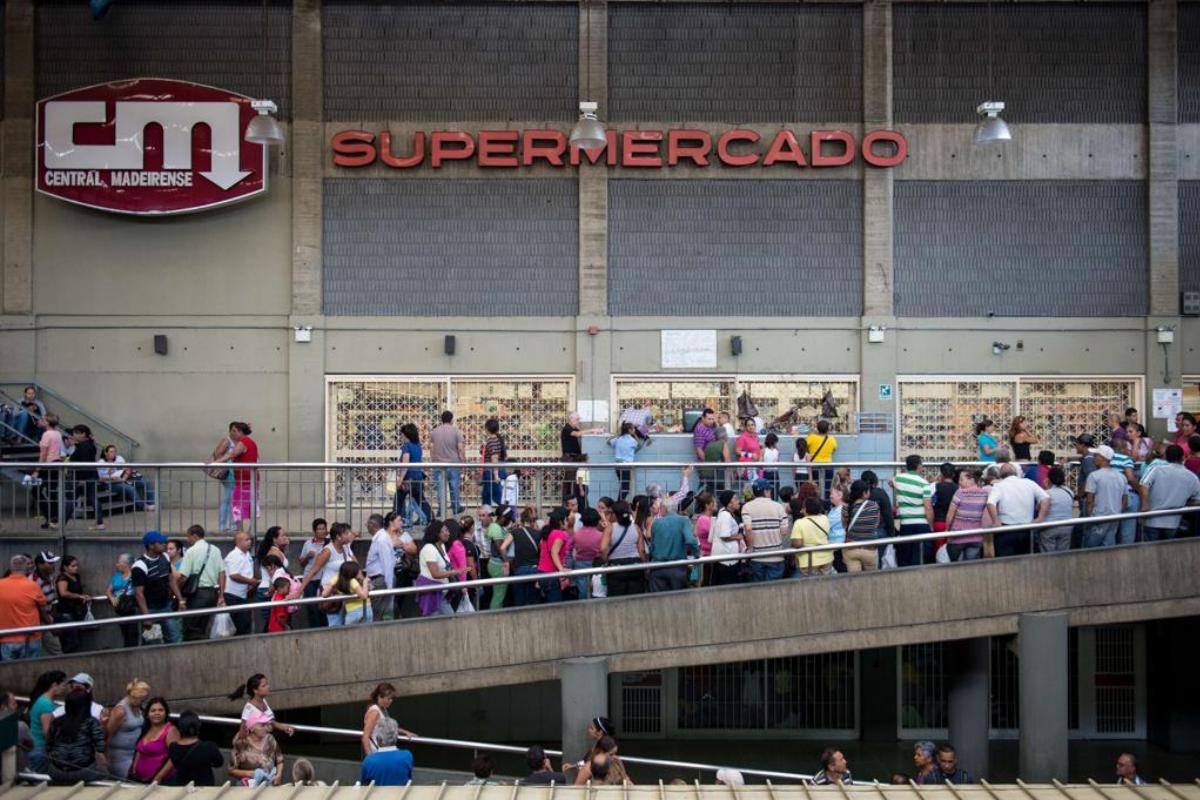 Venezuelanos fazem fila em frente a supermercado, em Caracas | FEDERICO PARRA/
AFP