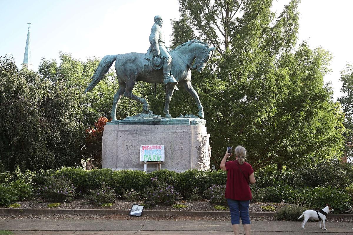 Um cartaz onde se lê que Heather Heyer repousa na base da estátua do general confederado Robert E. Lee, que fica no centro do Emancipation Park, em Charlottesville, Virgínia. Heather Heyer foi morta durante o protesto do fim de semana do dia 12 | MARK WILSON/AFP
