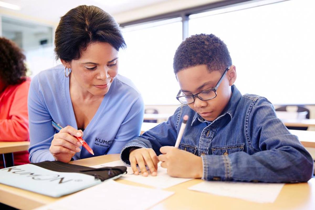Instrutora orienta aluno em classe do Kumon nos EUA | Divulgação / Kumon