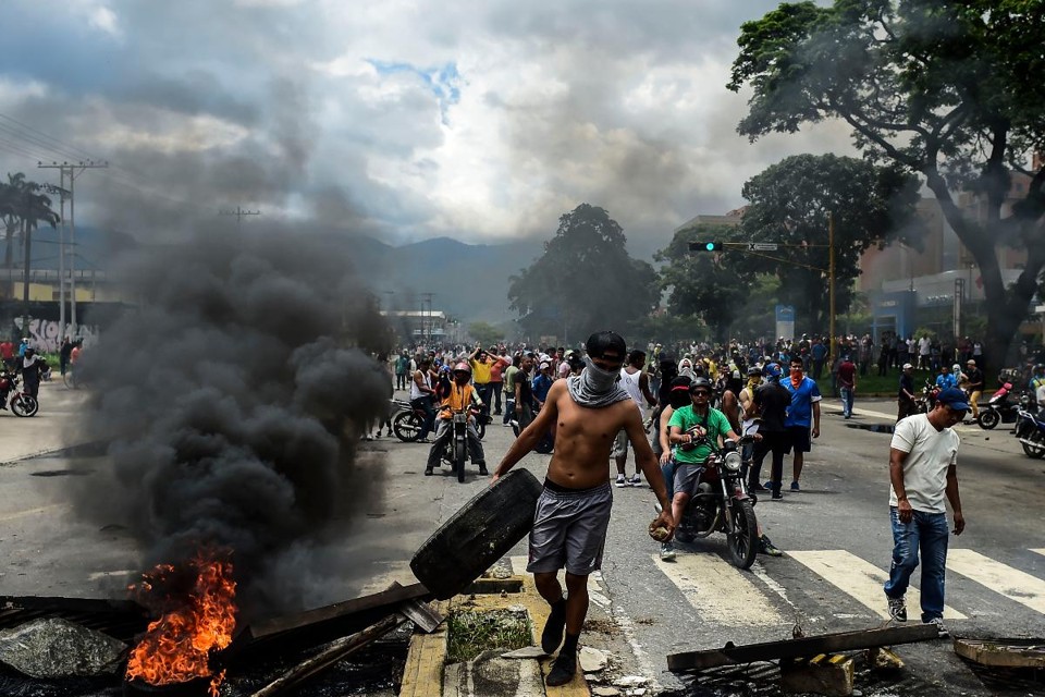 Cinco fatos relevantes para entender a situação da Venezuela neste momento Ativistas contrários ao governo constuíram barricadas nas ruas de Valência, no Norte da Venezuela | RONALDO SCHEMIDT/
AFP