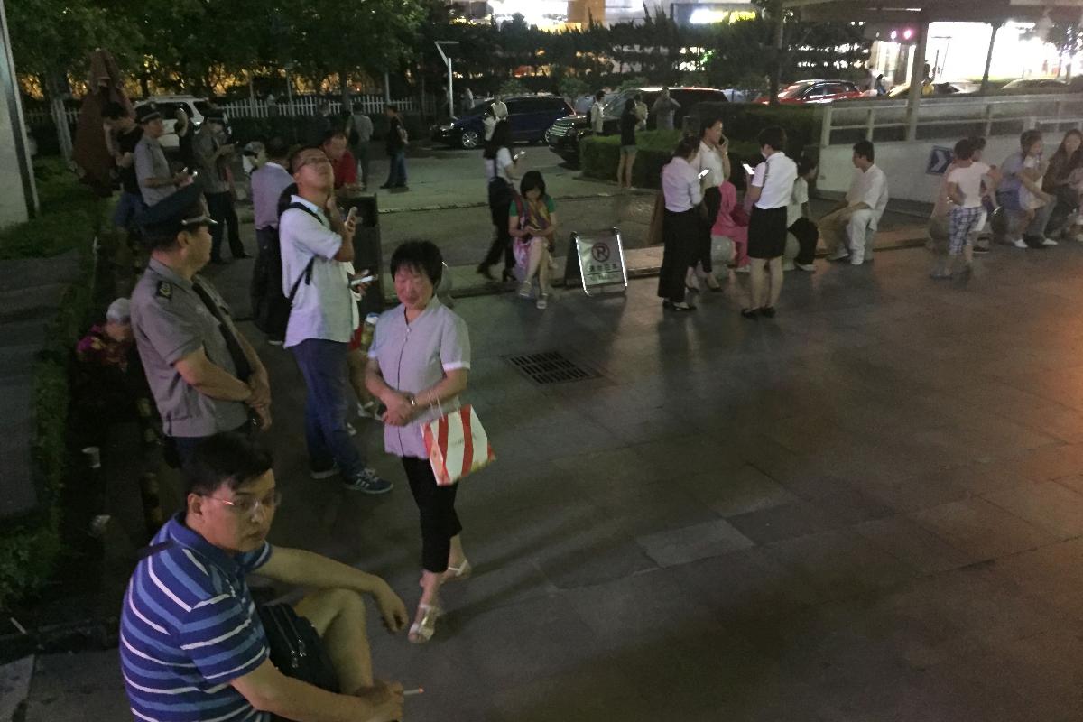 Pessoas fora de prédios depois do tremor de terra que atingiu parte da China nesta terça-feira | STR/AFP