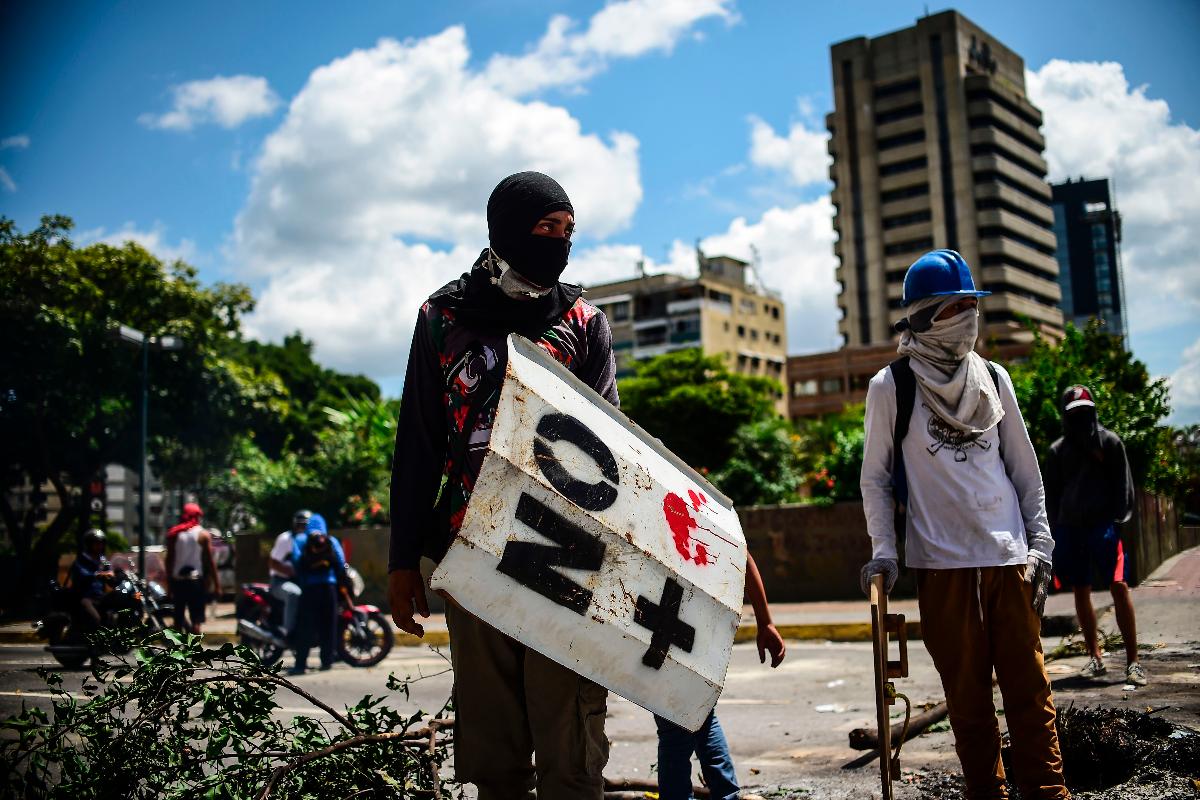 Ativistas anti-governo de Maduro protestam nas ruas de Caracas, na Venezuela | RONALDO SCHEMIDT/
AFP