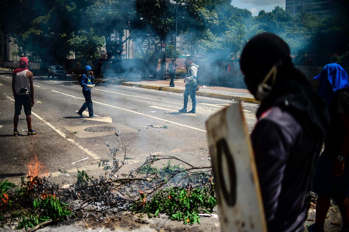 Ativistas anti-governo protestam em Caracas, na Venezuela; centenas de pessoas já foram mortas durante manifestações no país | RONALDO SCHEMIDT/
AFP