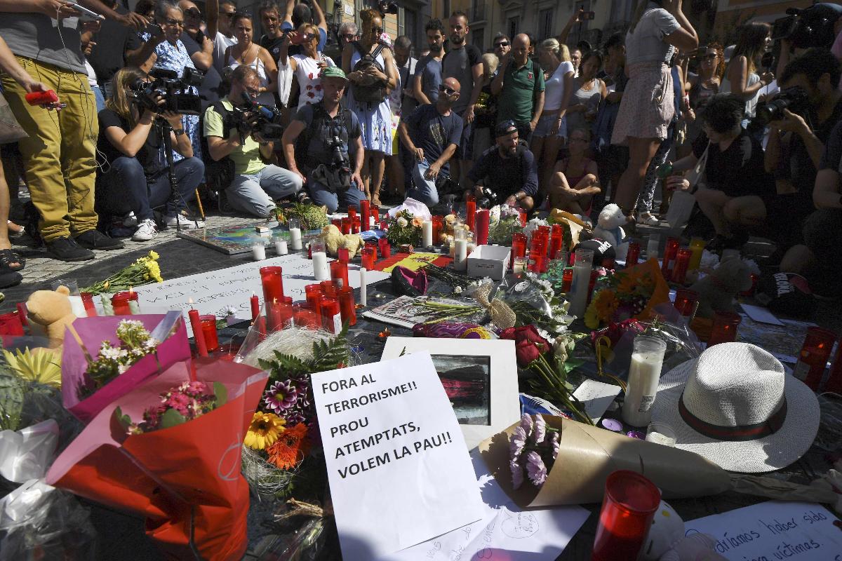 Pessoas se reunem em torno de flores, velas e cartazes de condolência a vítimas de atentado em Barcelona | PASCAL GUYOT/AFP