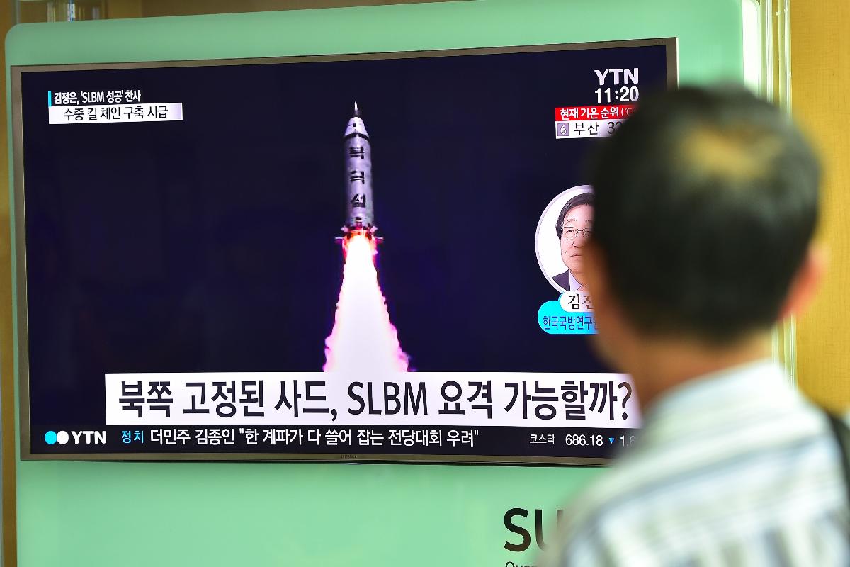 Sul-coreano em estação ferroviária de Seul (foto de agosto de 2016) observa notícias sobre teste de mísseis balísticos lançados por submarino da Coréia do Norte | JUNG YEON-JE/AFP