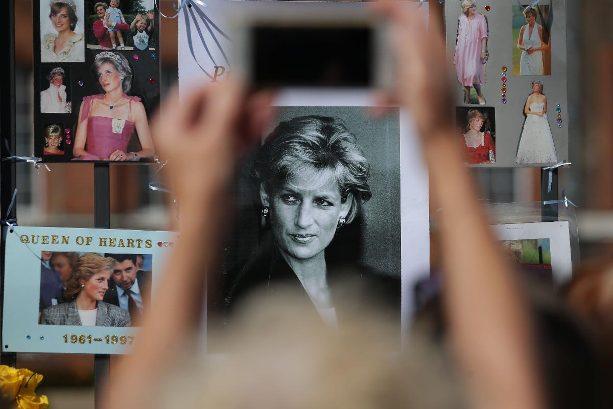 Público se reúne para prestar tributo com flores, velas e fotografias fora de um dos portões do Palácio de Kensington, em Londres, em 31 de agosto de 2017, para marcar o 20º aniversário da morte de Diana, Princesa de Gales | DANIEL LEAL-OLIVAS/
AFP