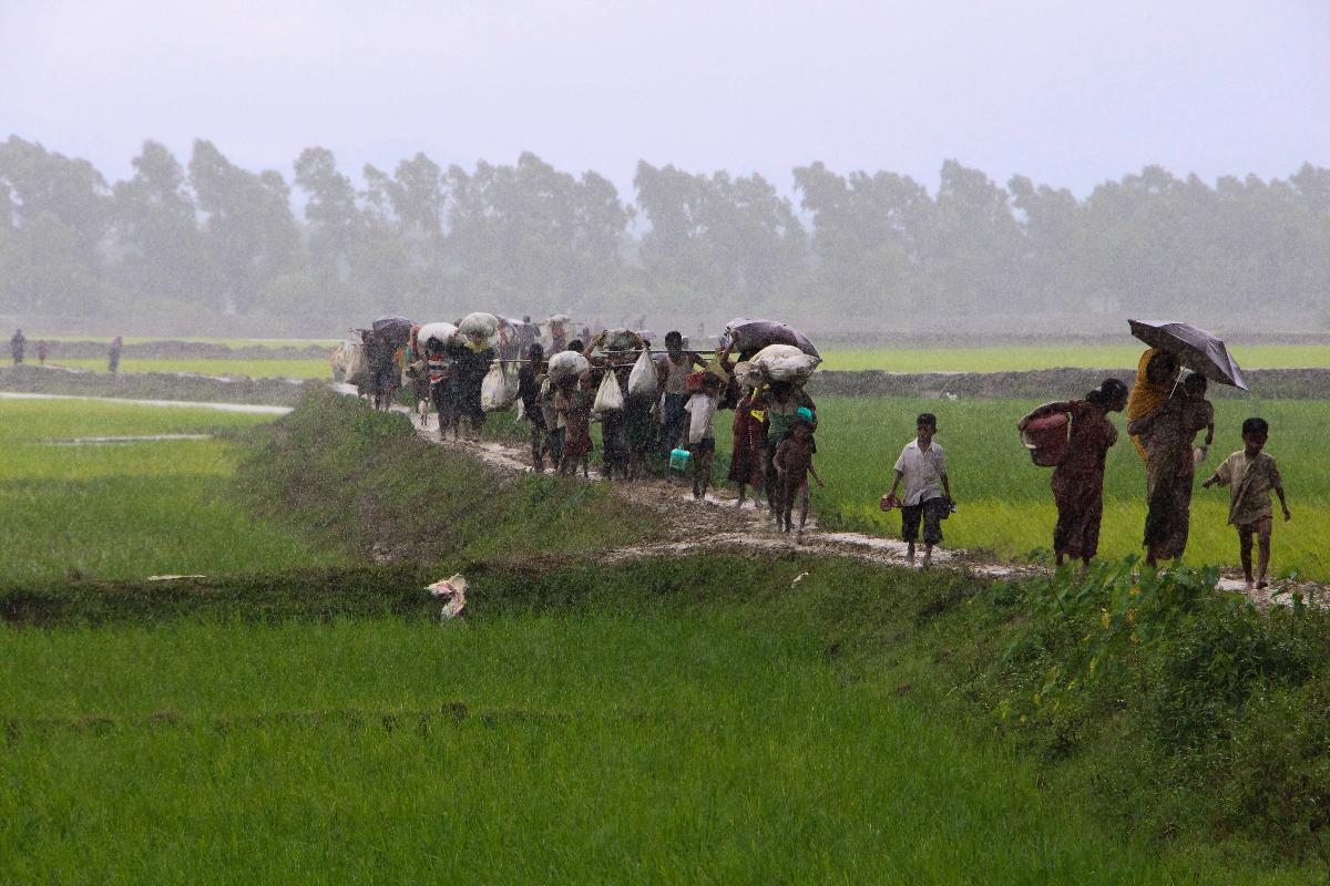 Refugiados rohingya do estado de Rakhine, em Myanmá, caminham por um caminho perto de Teknaf, em Bangladesh, em 2 de setembro de 2017. Cerca de 400 pessoas - a maioria deles muçulmanos Rohingya - morreram violentamente na última semana, e dezenas de milhares foram forçados a fugir para Bangladesh. Mais de 20.000 rohingya se espalharam pela fronteira de Bangladesh, impedidos de entrar no país, enquanto dezenas de pessoas desesperadas se afogaram tentando atravessar o Naf, um rio fronteiriço, em barcos improvisados. | SUZAUDDIN RUBEL/AFP