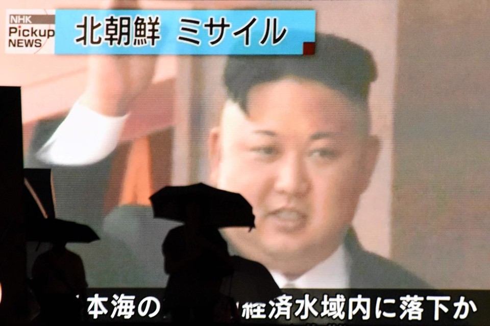 Imagens do líder norte-coreano Kim Jong-un, após testes de lançamento de míssil, vistas por pedestres que passam por telão em Tóquio, no Japão | KAZUHIRO NOGI/
AFP